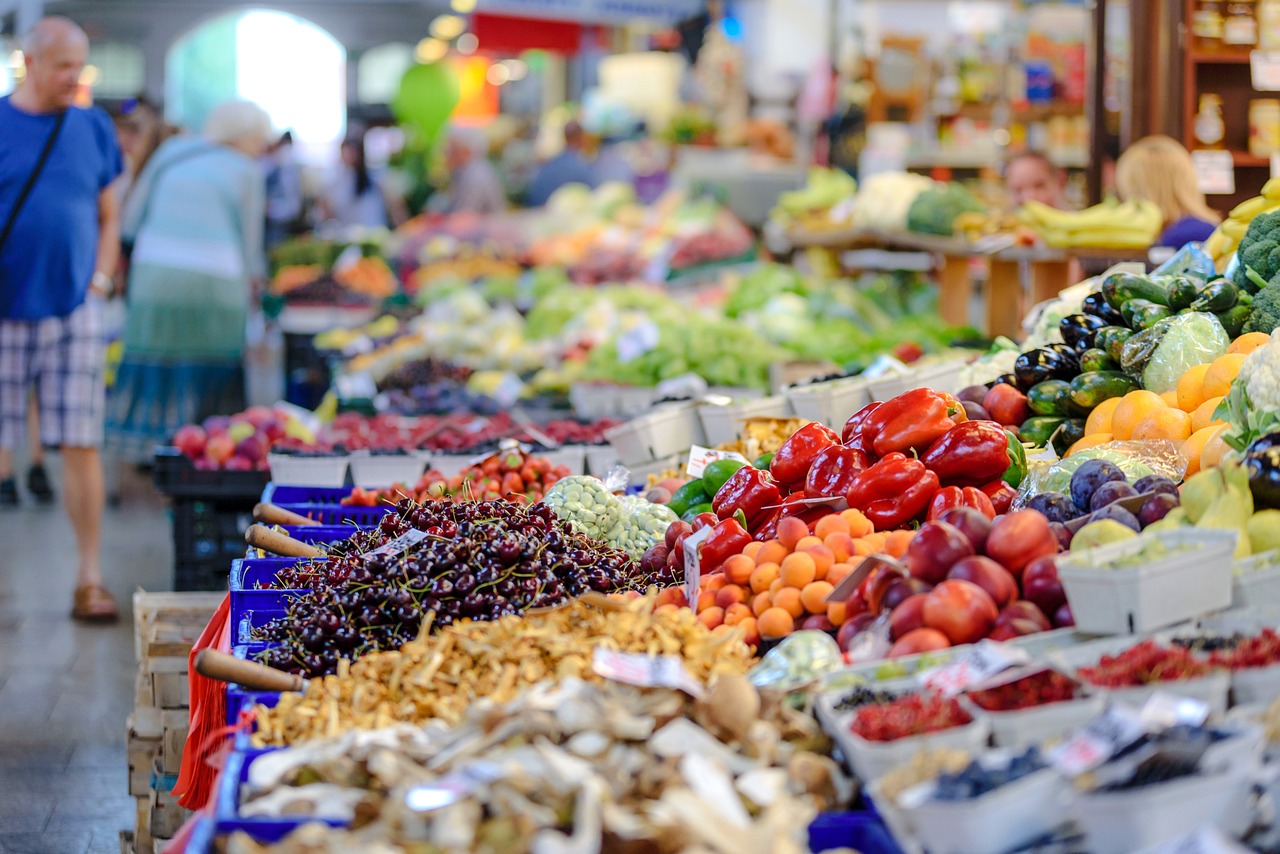 Markt met uitgestald verkoopwaar waaronder veel groenten en fruit